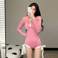 Women's long sleeve one-piece swimsuit in pink and black, showing front and back views.