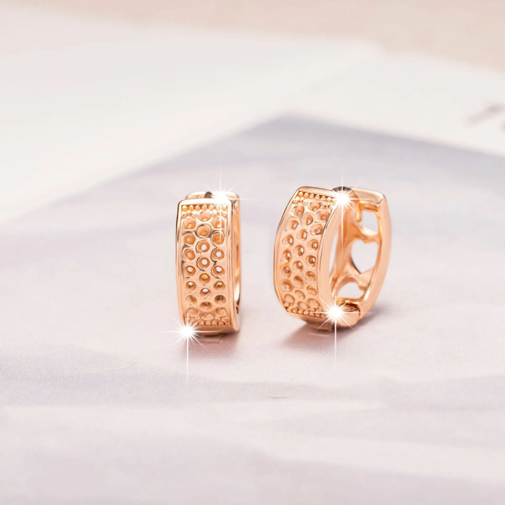 Rose gold circular earrings with three hollow heart cut-outs