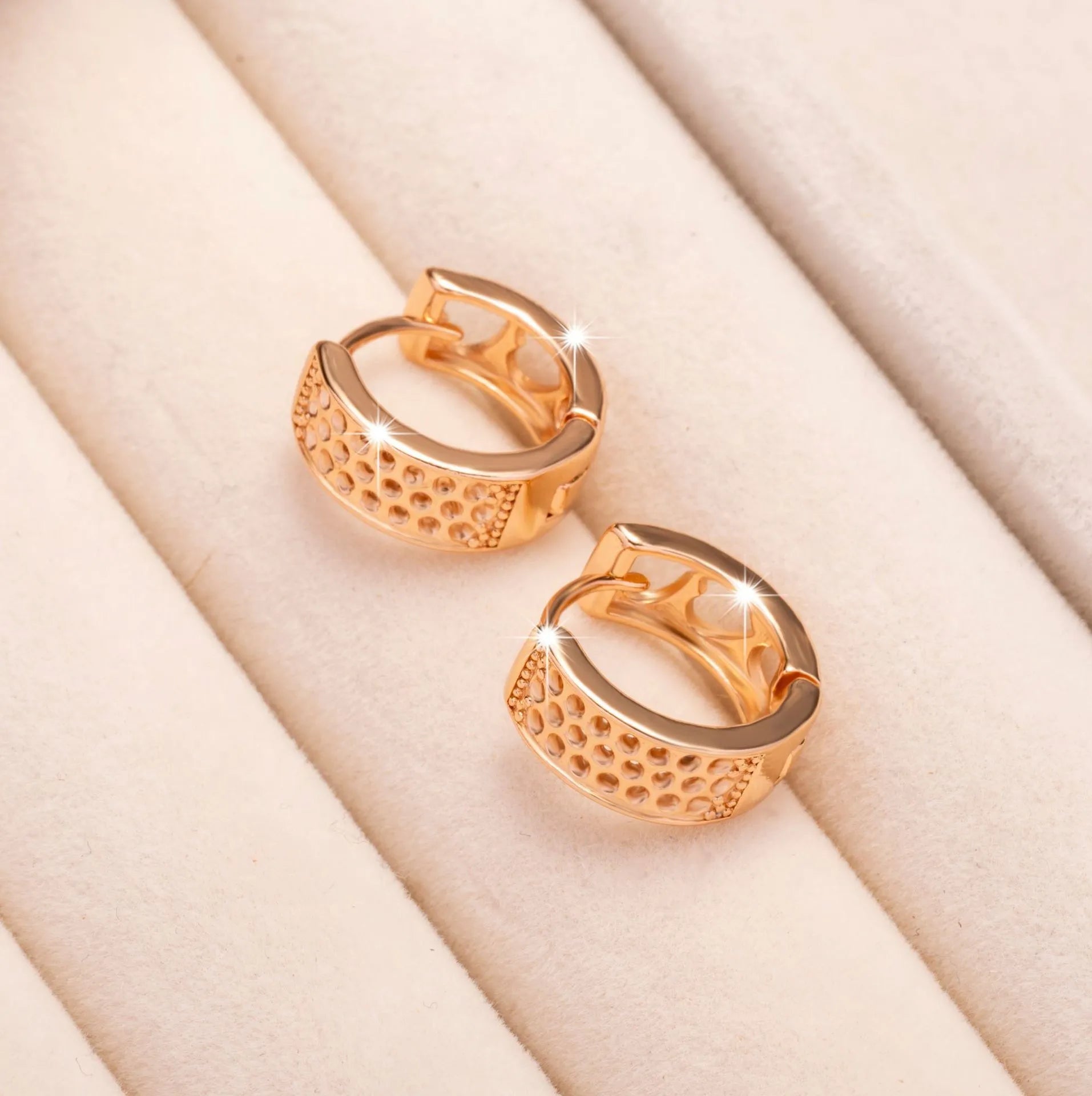 Rose gold circular earrings with three hollow heart cut-outs