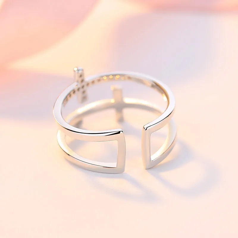 Adjustable copper ring with double cross design, white gold electroplated finish, and zircon gemstones in sterling silver inlays