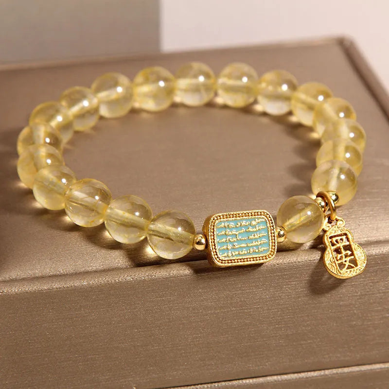 Women's natural yellow crystal bracelet with citrine colour round beads and rhinestone accents, sliding knot closure