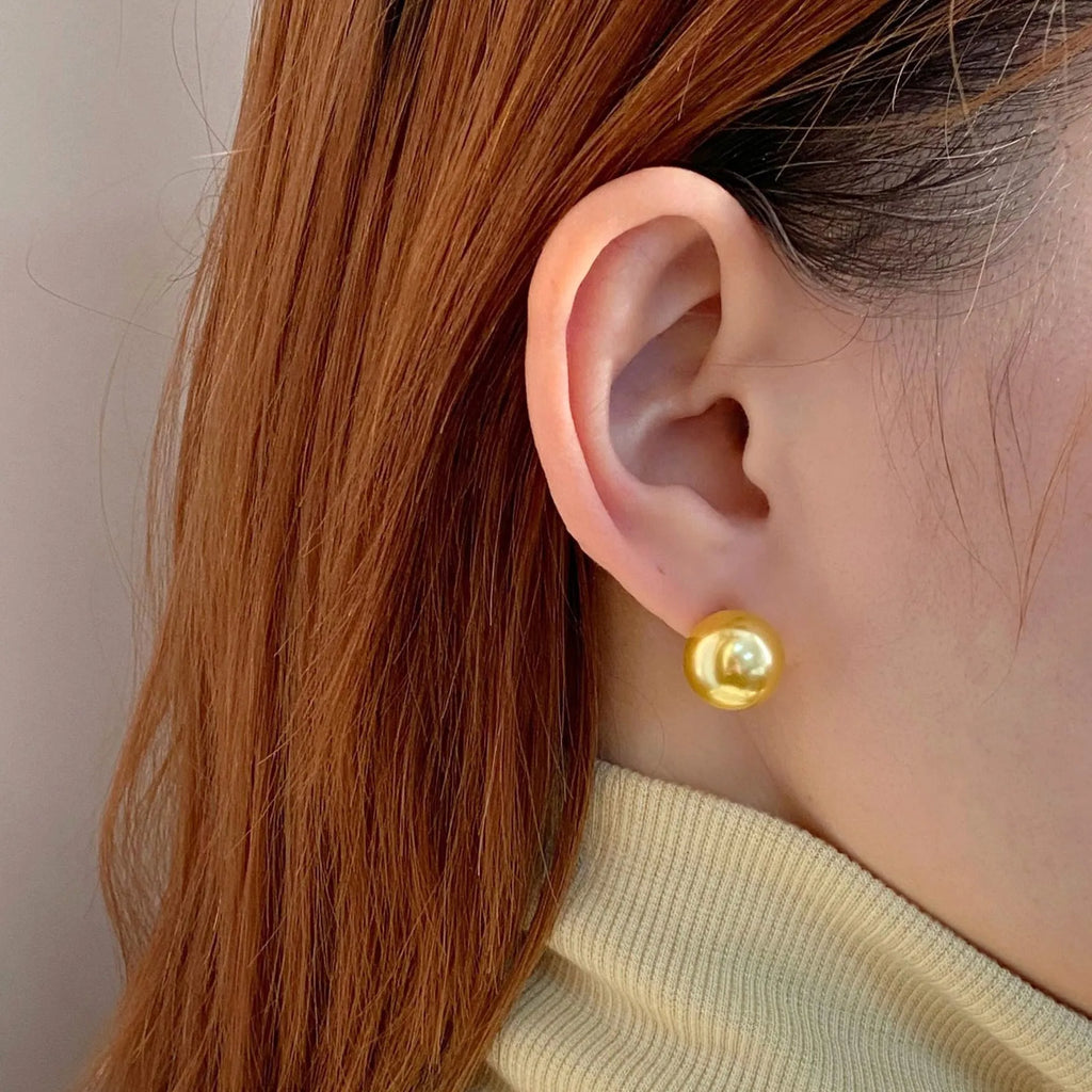 Geometric large pearl stud earrings with eight-point star design in silver setting.