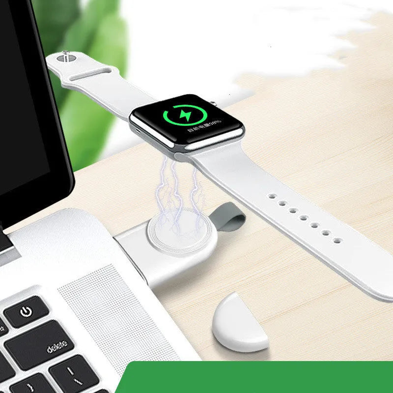 Portable Apple Watch wireless charging dock in white on a wooden table, with USB cable attached.