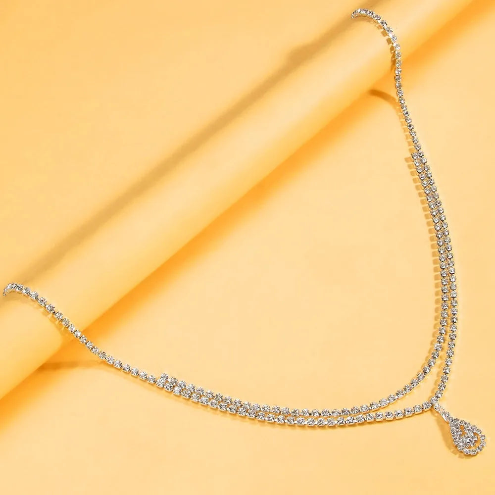 Gold water drop pendant waist chain with sparkling rhinestone tassel and lobster buckle.