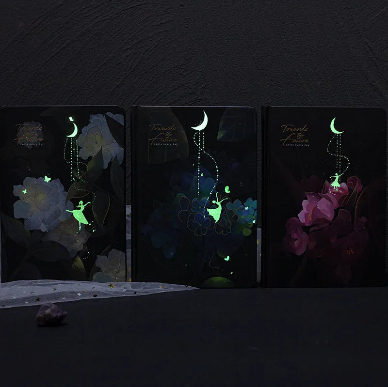 A5 notebook with luminous colourful illustration cover shown in deep blue, gold, light blue, and purple colour options.