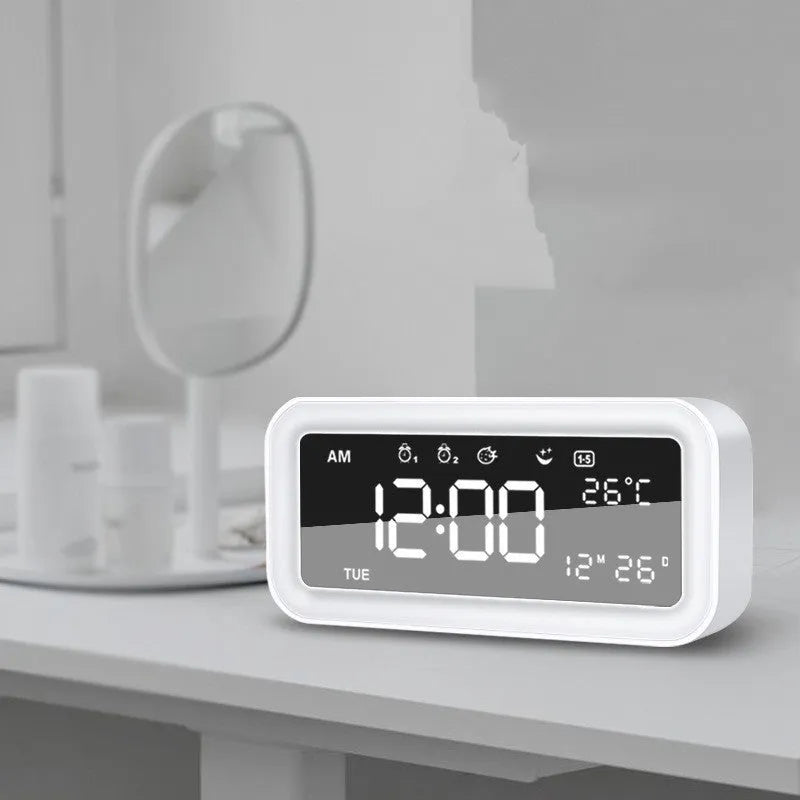Blue rectangular LED atmosphere light alarm clock with digital display on a wooden desk.