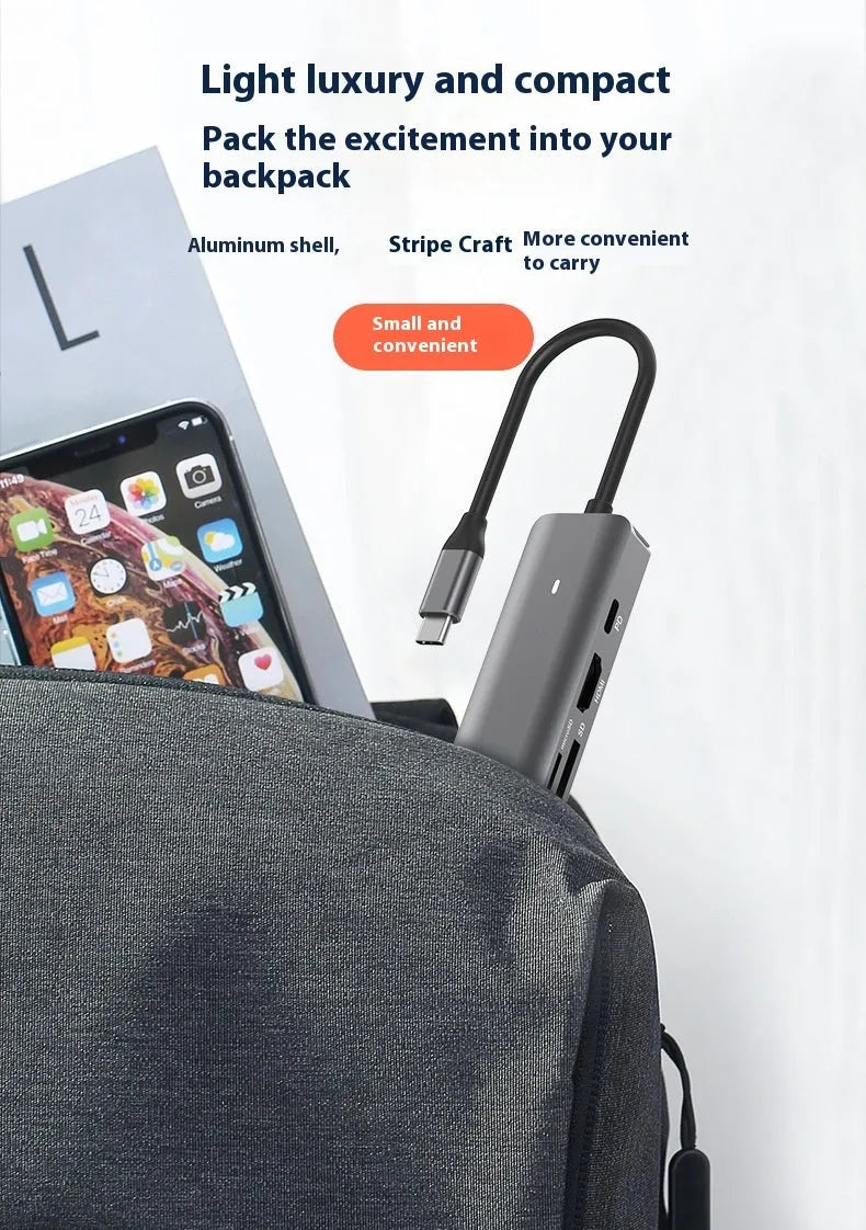 Silver aluminium USB C 7-in-1 hub with HDMI, USB 3.0 ports, and SD card slots.
