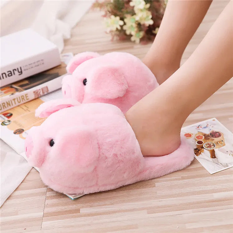 Pair of soft pink pig-shaped plush slippers with a cute animal face design.