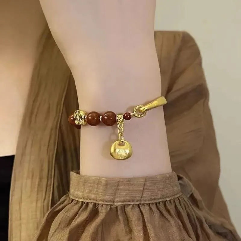 Golden South Red Agate Character Ingot Bracelet with lucky bag charm on a white background