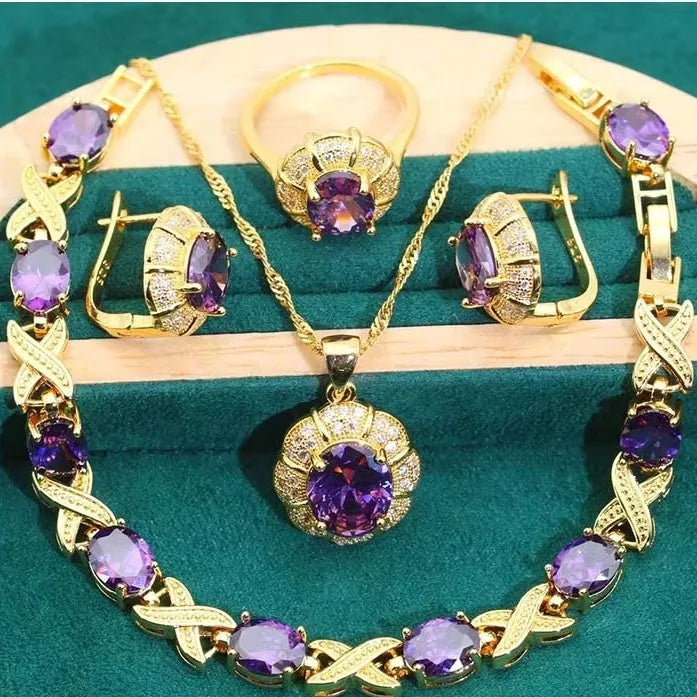 Four piece 18K gold plated jewellery set with coloured cubic zirconia stones including necklace earrings ring and bracelet