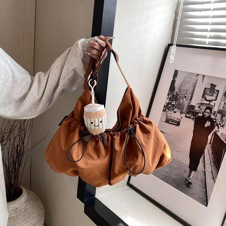 Ultra-light pleated crossbody student cloth bag in soft polyester, showing split pocket and internal phone storage.
