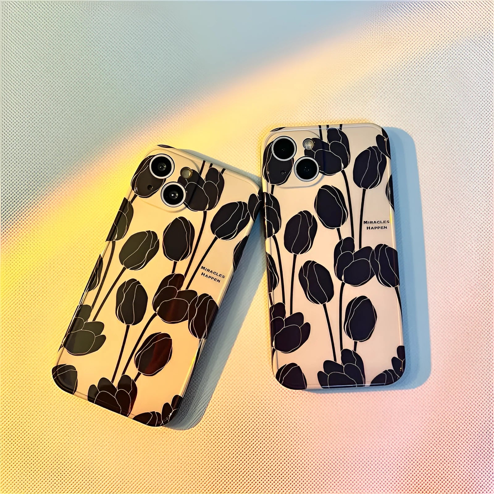 Black silicone iPhone case with a white tulip floral graphic on the back