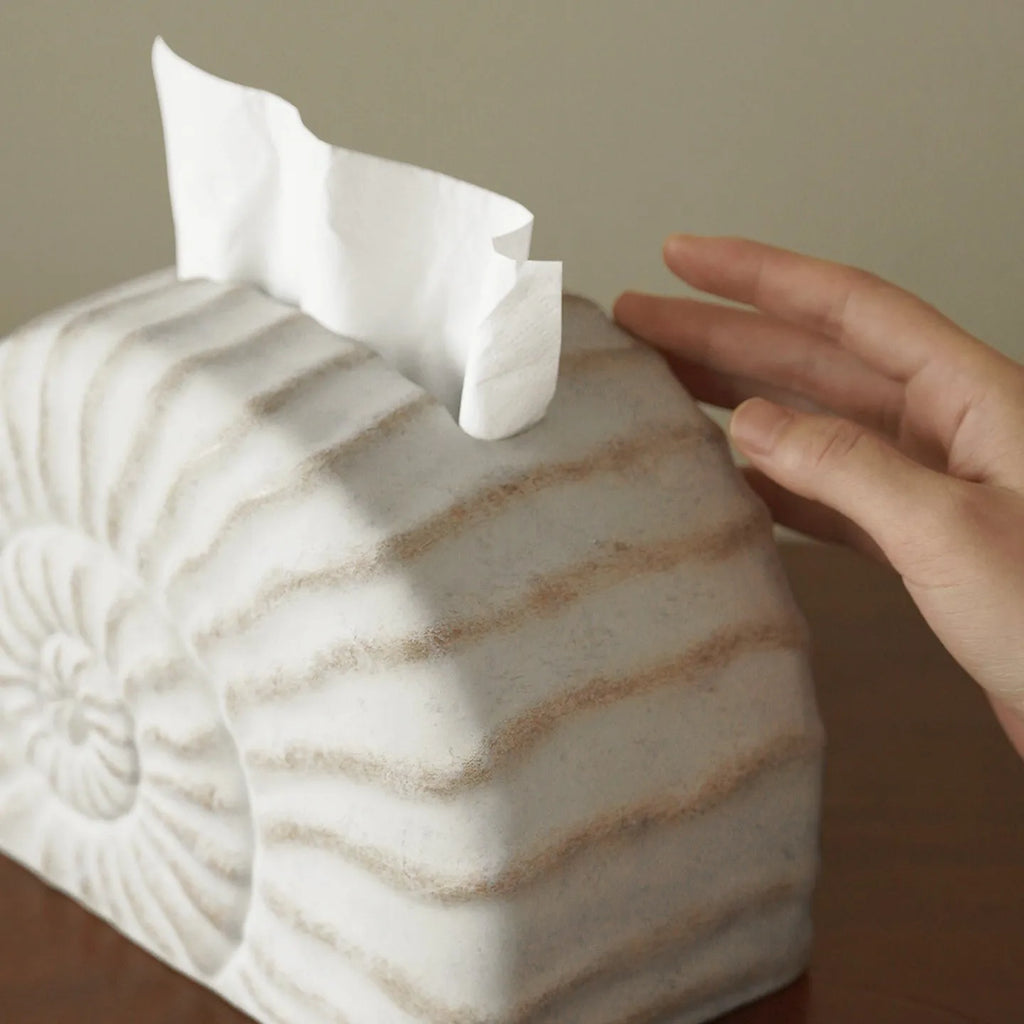 White conch shell shaped resin cover for a rectangular tissue box with a slot for tissue dispensing.