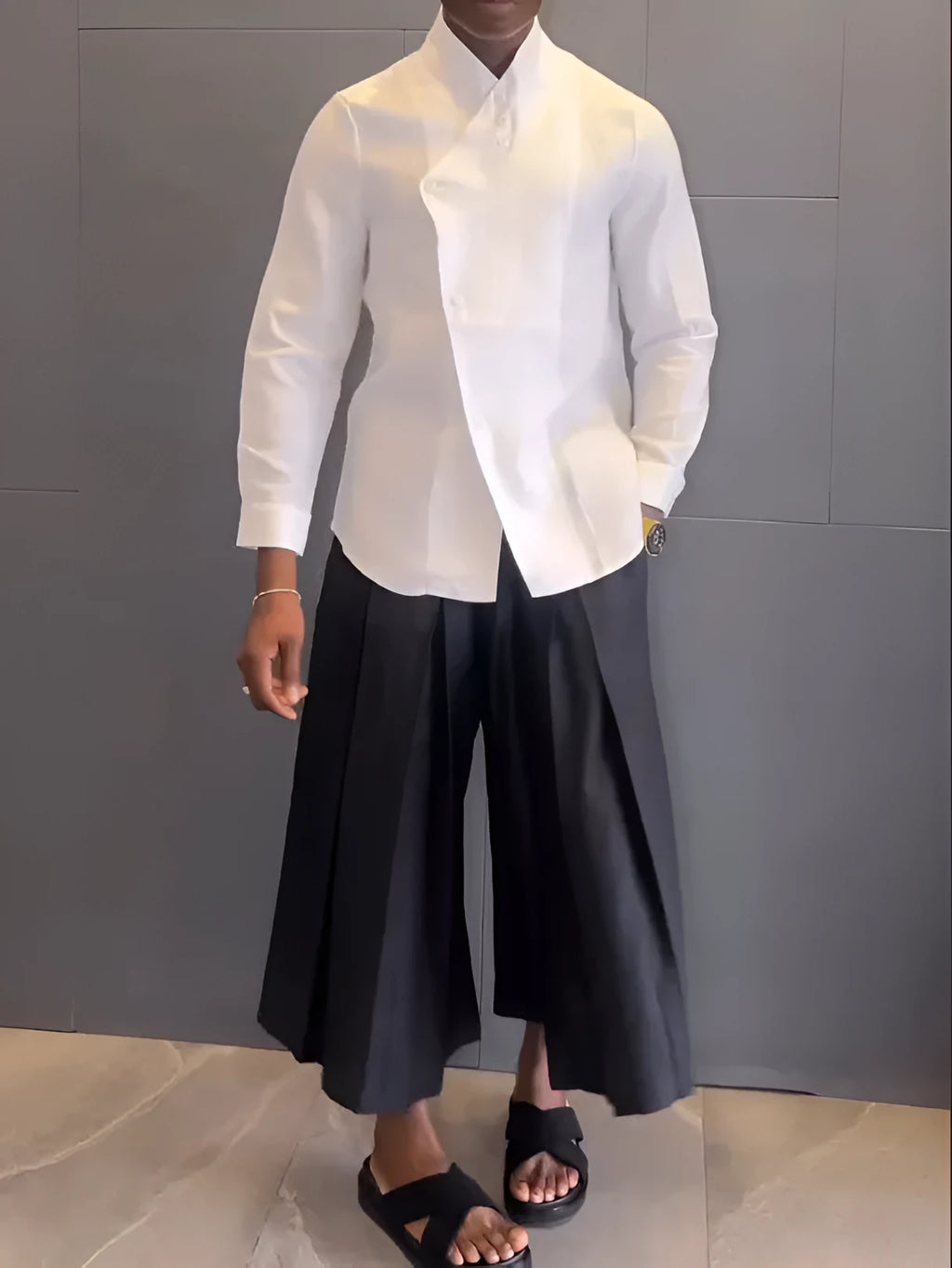 White asymmetric front long sleeve shirt and black pleated pants set on display