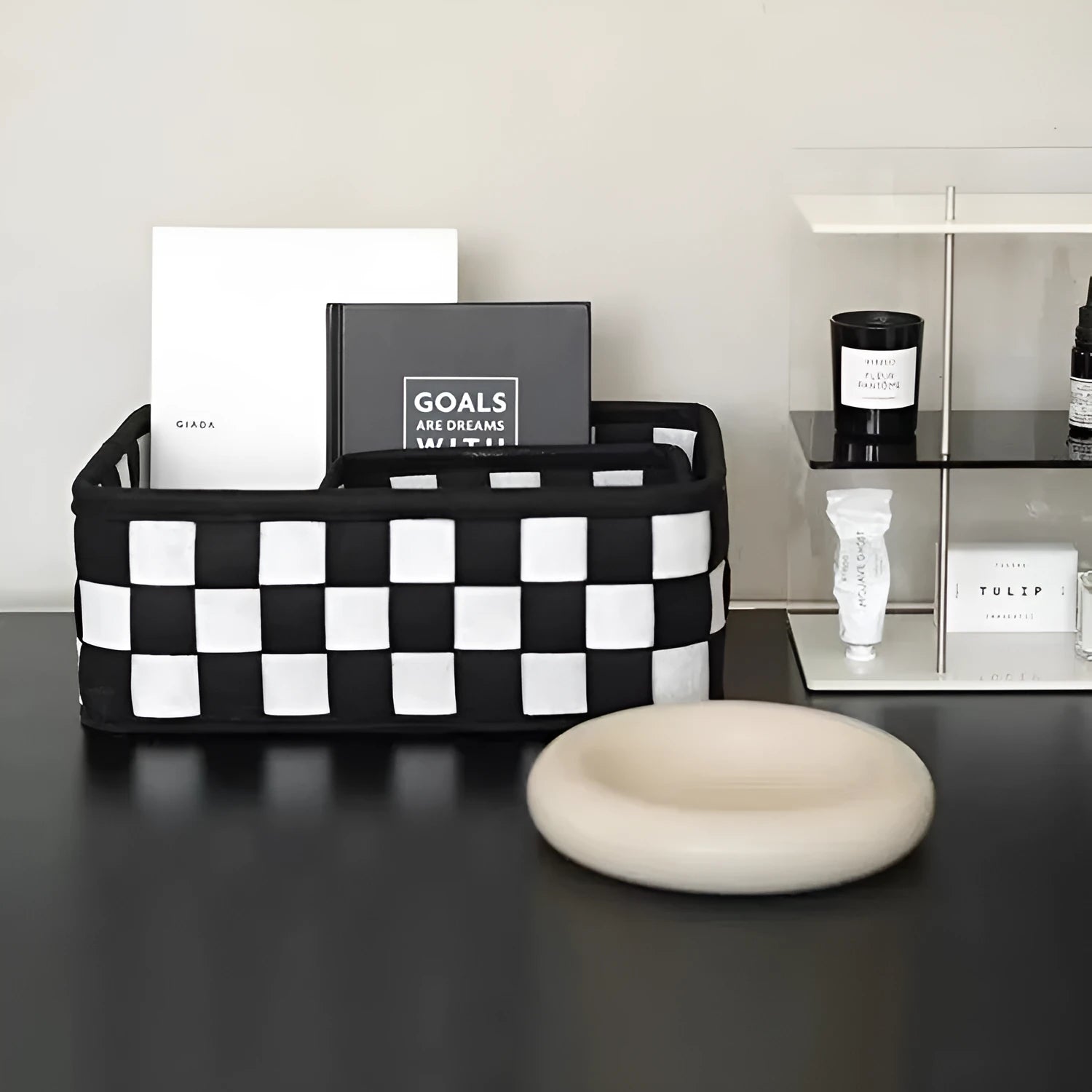 Black and white checkerboard woven felt storage basket with folded sides.
