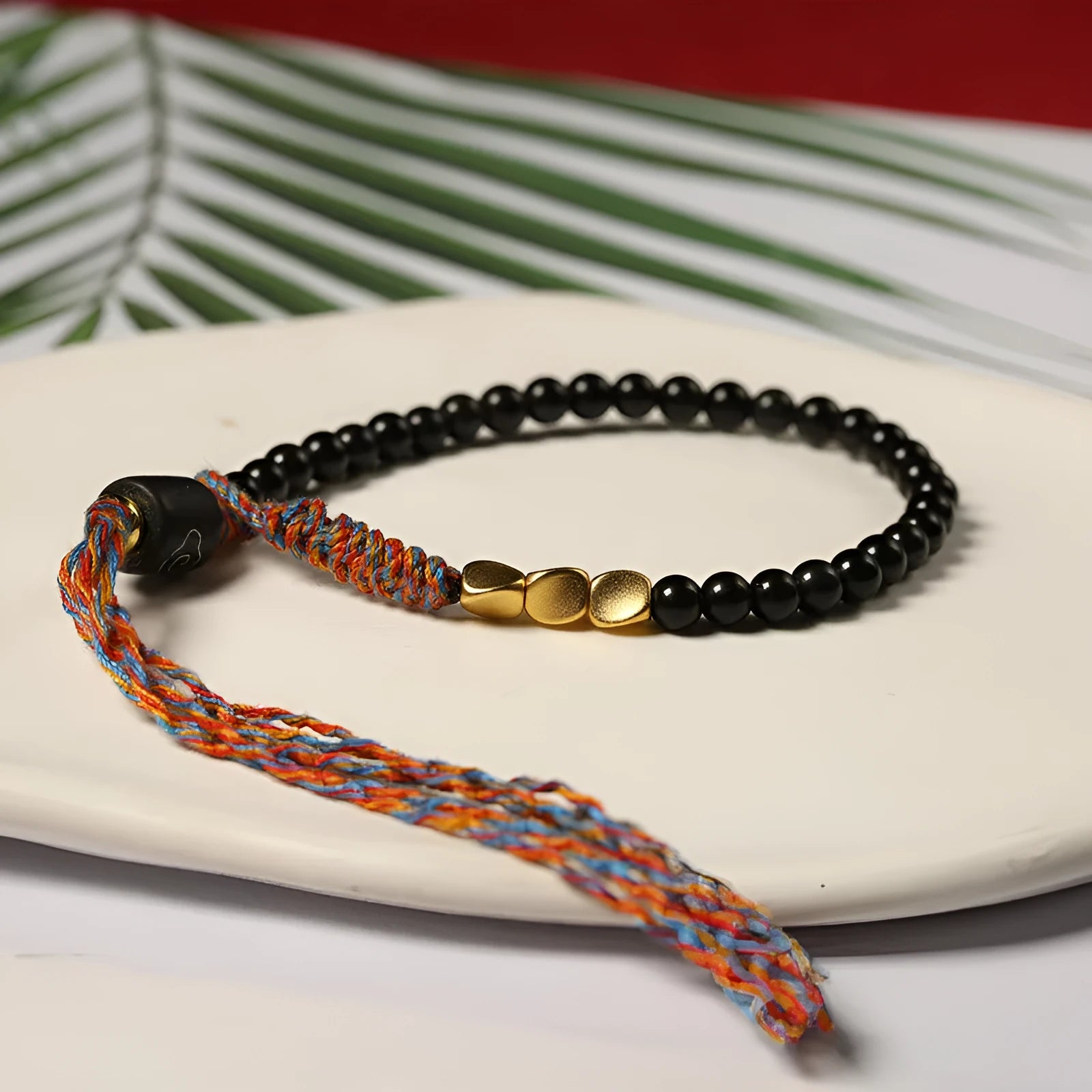 Obsidian coloured hand-woven leather strap bracelet with adjustable fastening on a wrist.