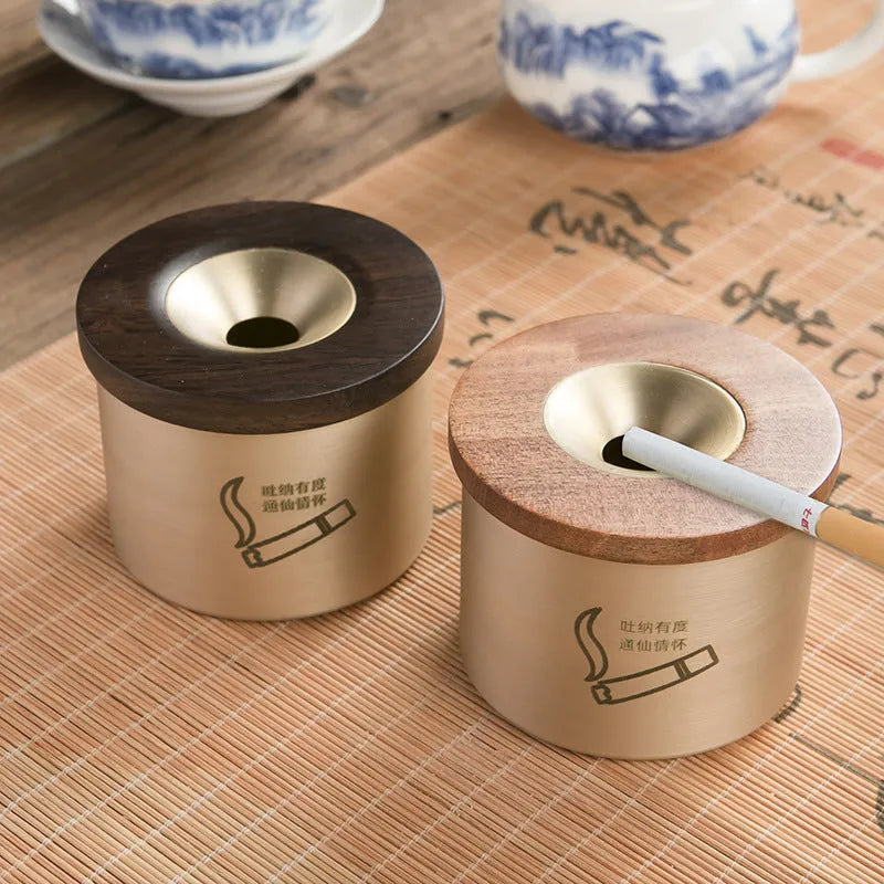 Brass ashtray with wooden lid showing central aperture design