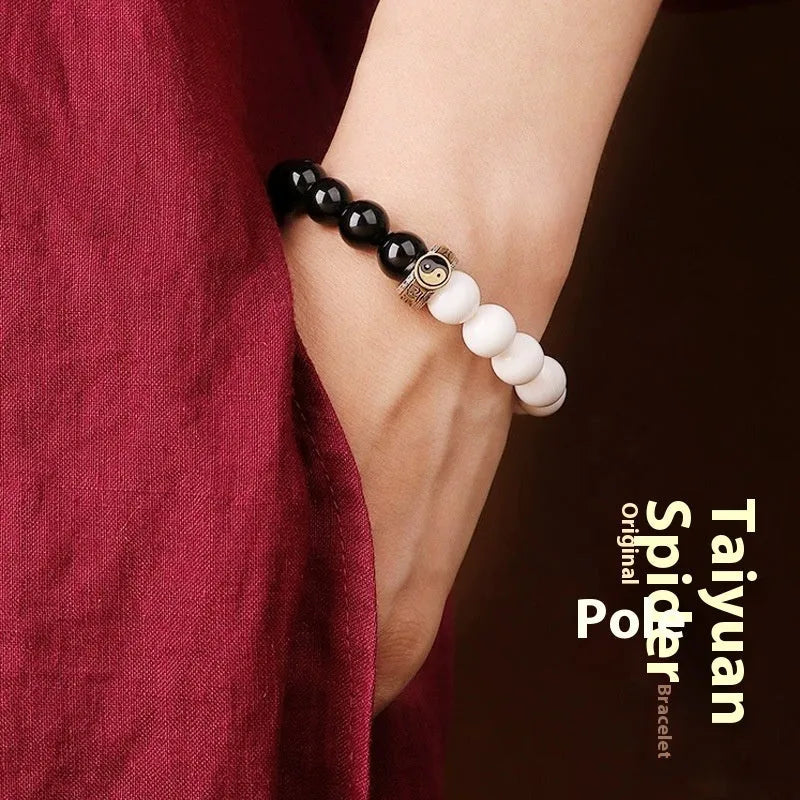 Black and white obsidian geometry-shaped bead bracelet on neutral background