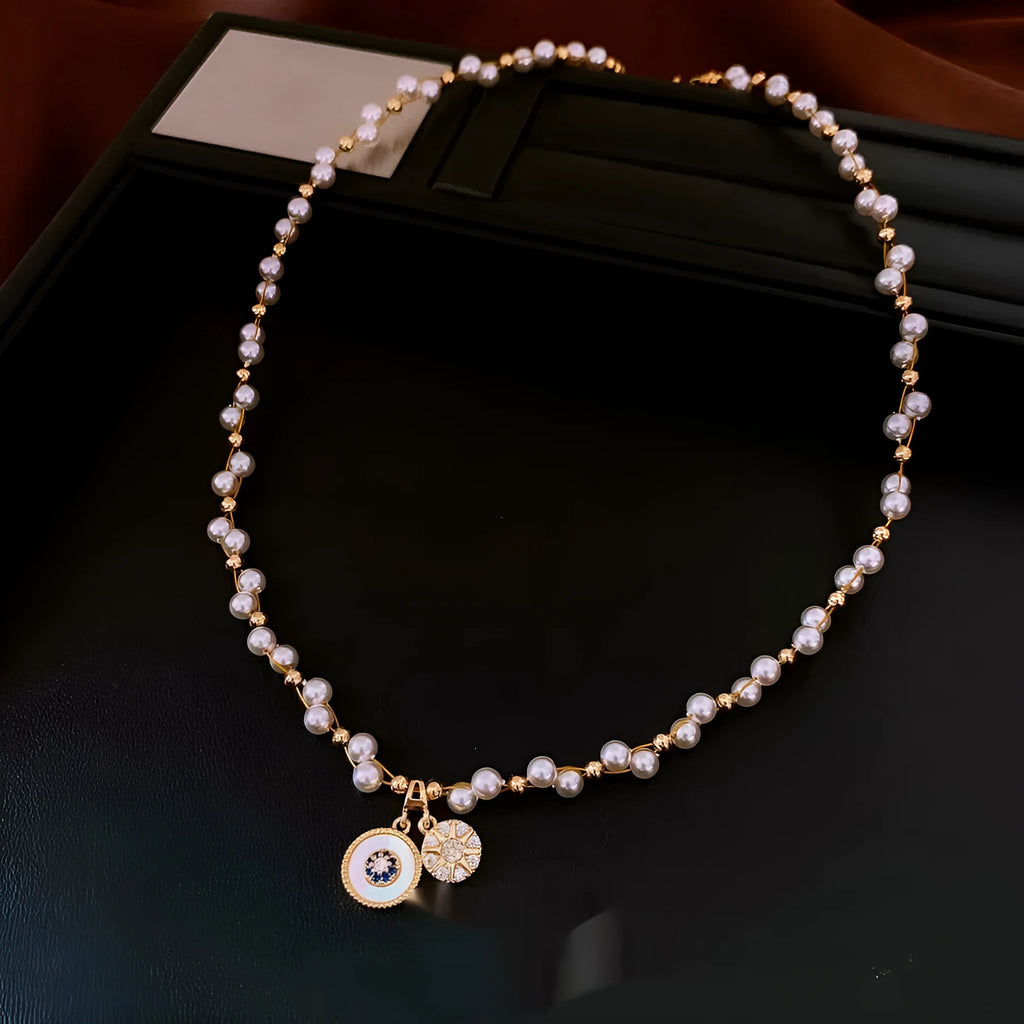 Gold electroplated round pendant necklace with zircon pearl on an adjustable clavicle chain.