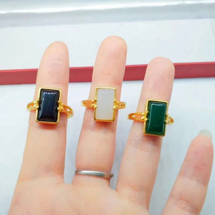 Adjustable brass gold-plated ring with electroplated finish and a coloured gemstone.