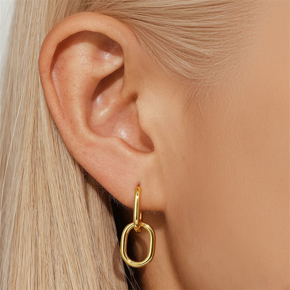 A pair of round, geometric brass earclip earrings with a gold electroplated finish.