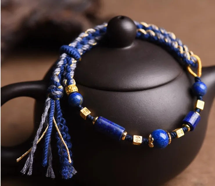 Hand-woven lapis lazuli flexible wire bracelet with simple ethnic design on white background