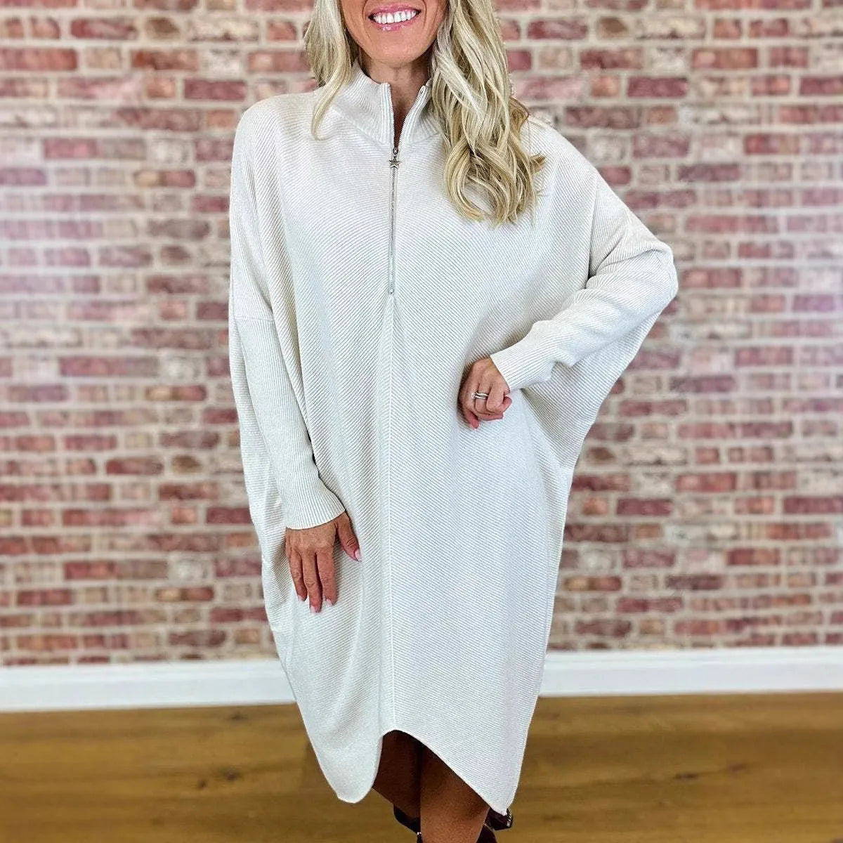 Women's solid colour loose knitted dress with a zipper detail on a hanger.
