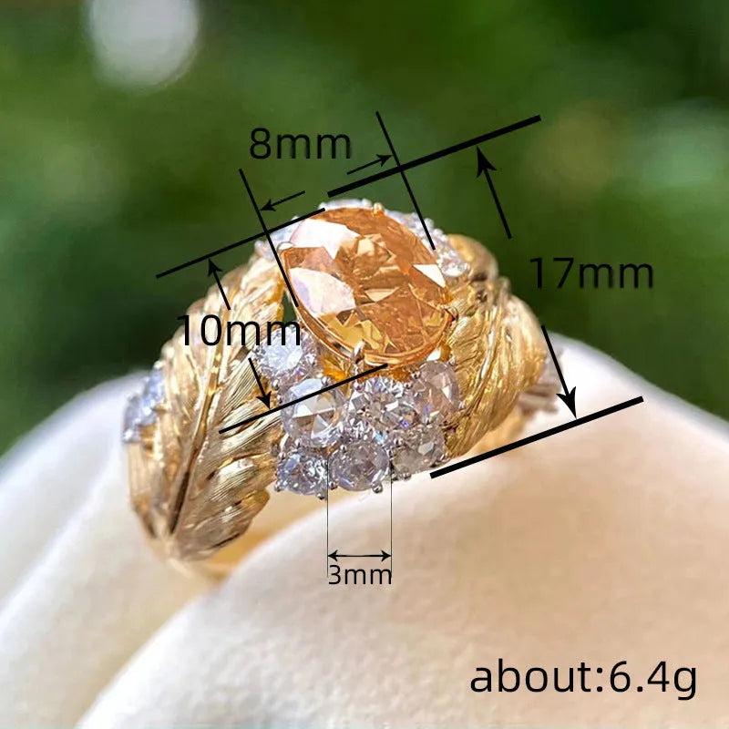 Yellow gold colour women's ring with an embossed feather design and a small inlaid zircon stone.