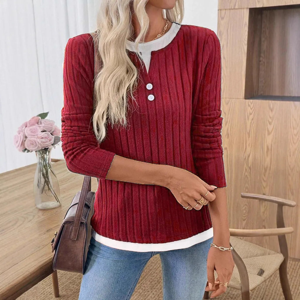Women's black fake two-piece pullover sweater with button front and round neck on a hanger.