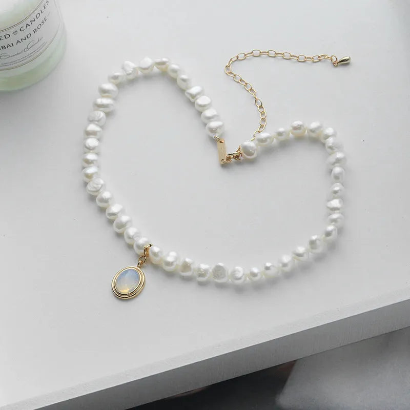 Silver geometric necklace with an irregular pearl pendant on an adjustable chain.