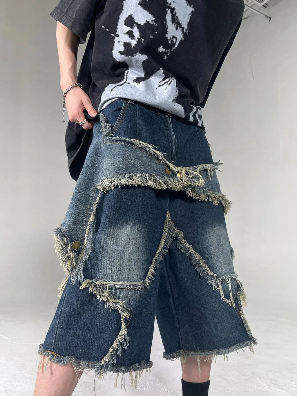 Blue denim shorts with five-pointed star embroidery and frayed edges, loose fit silhouette