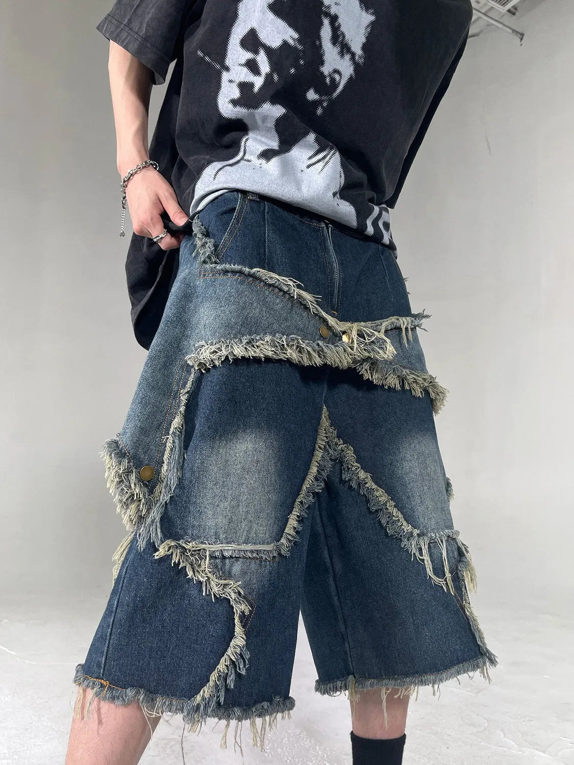 Blue denim shorts with five-pointed star embroidery and frayed edges, loose fit silhouette