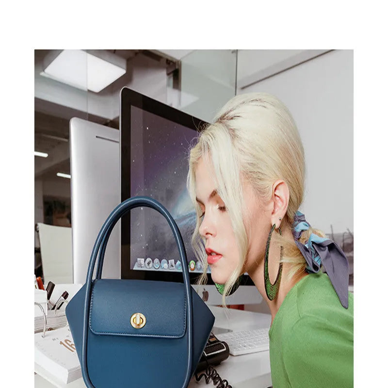 Soft wing-shaped leather cross-body tote bag in cow leather with a buckle and latch closure.