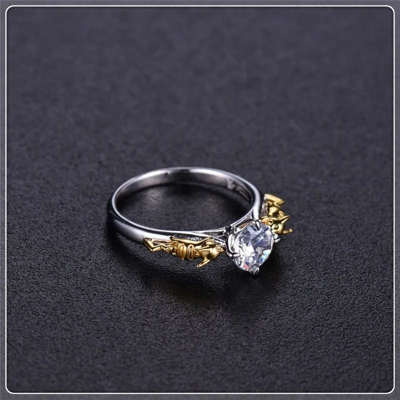 Copper crown ring with crystals in a black gold finish, shown on a finger.