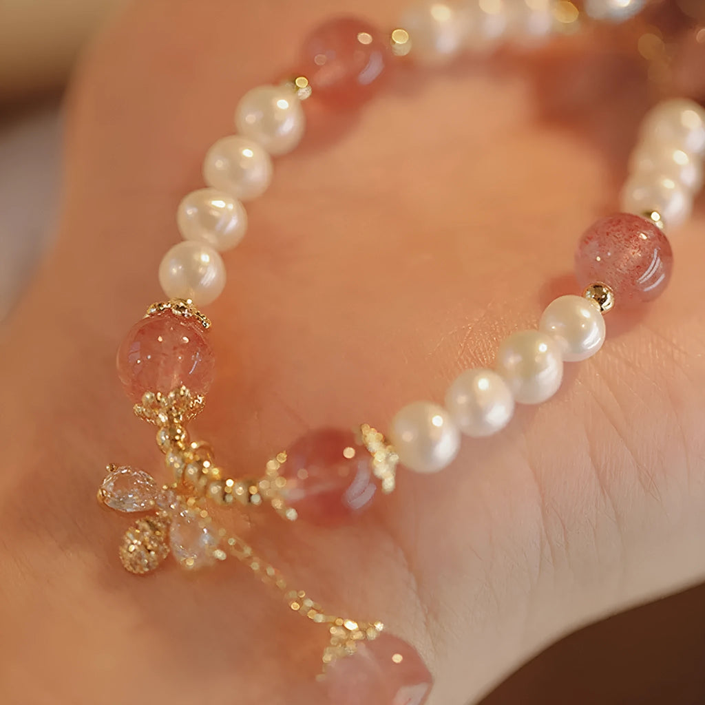 Close-up of a handmade crystal and strawberry quartz bracelet with a bow design, styled for women, INS aesthetic.