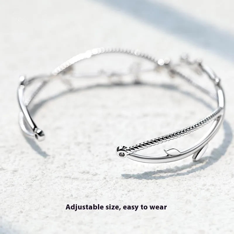 White gold copper branch sprout bracelet with twisted cross design on wrist