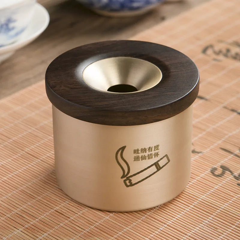 Brass ashtray with wooden lid showing central aperture design