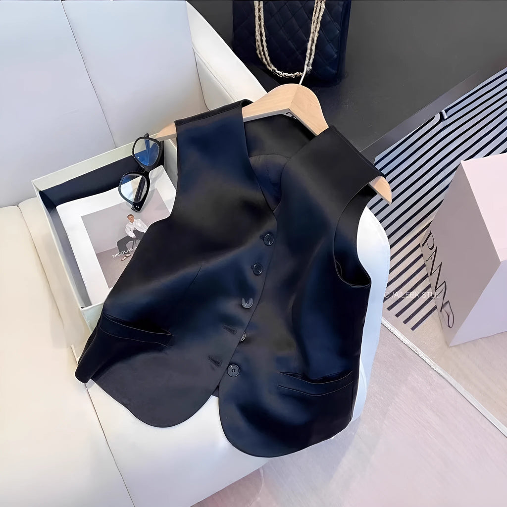 Black satin sleeveless vest for women on a hanger, showing loose fit and V-neck.