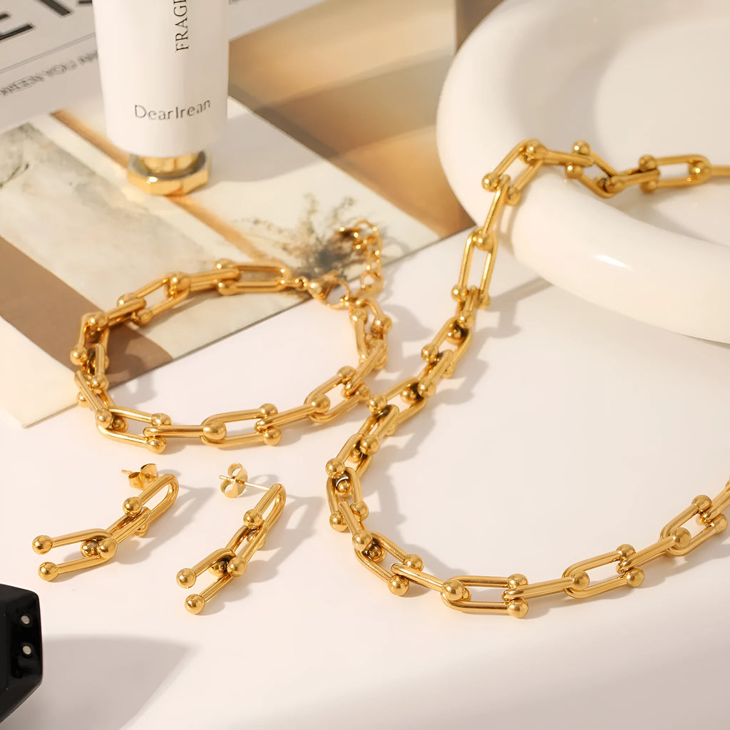 Stainless steel jewellery set including a necklace with titanium steel pendant, bracelet, and earrings in a matching colour