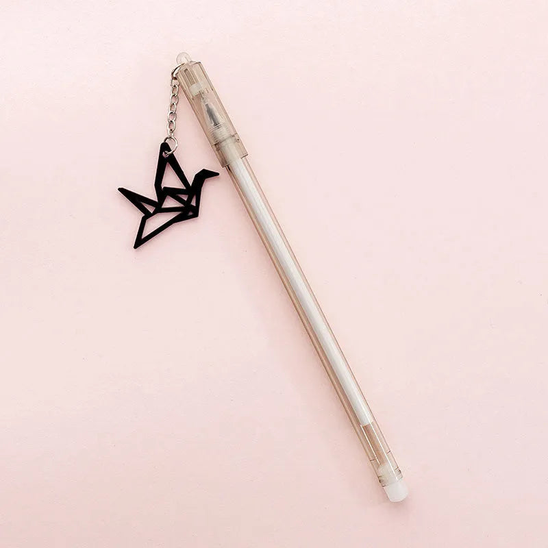 White gel pen with paper crane pendant and black gel pen with rabbit pendant on cap.