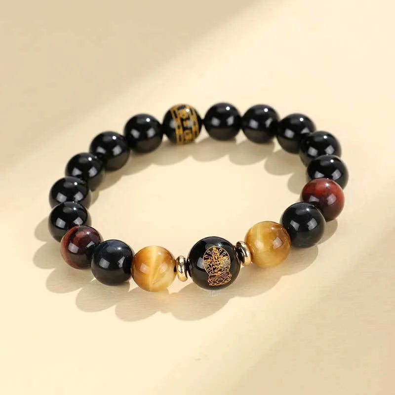 Black agate beaded bracelet with tiger eye stones in ethnic style on plain background
