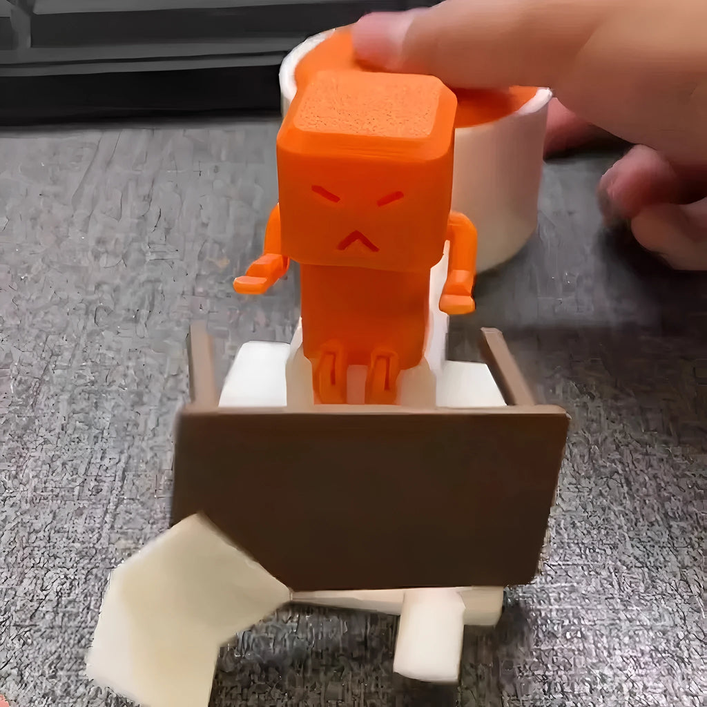 Orange plastic vent decompression toy on desk showing table turning mechanism