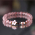Women's strawberry quartz crystal bracelet with flower-shaped peach blossom design on wrist