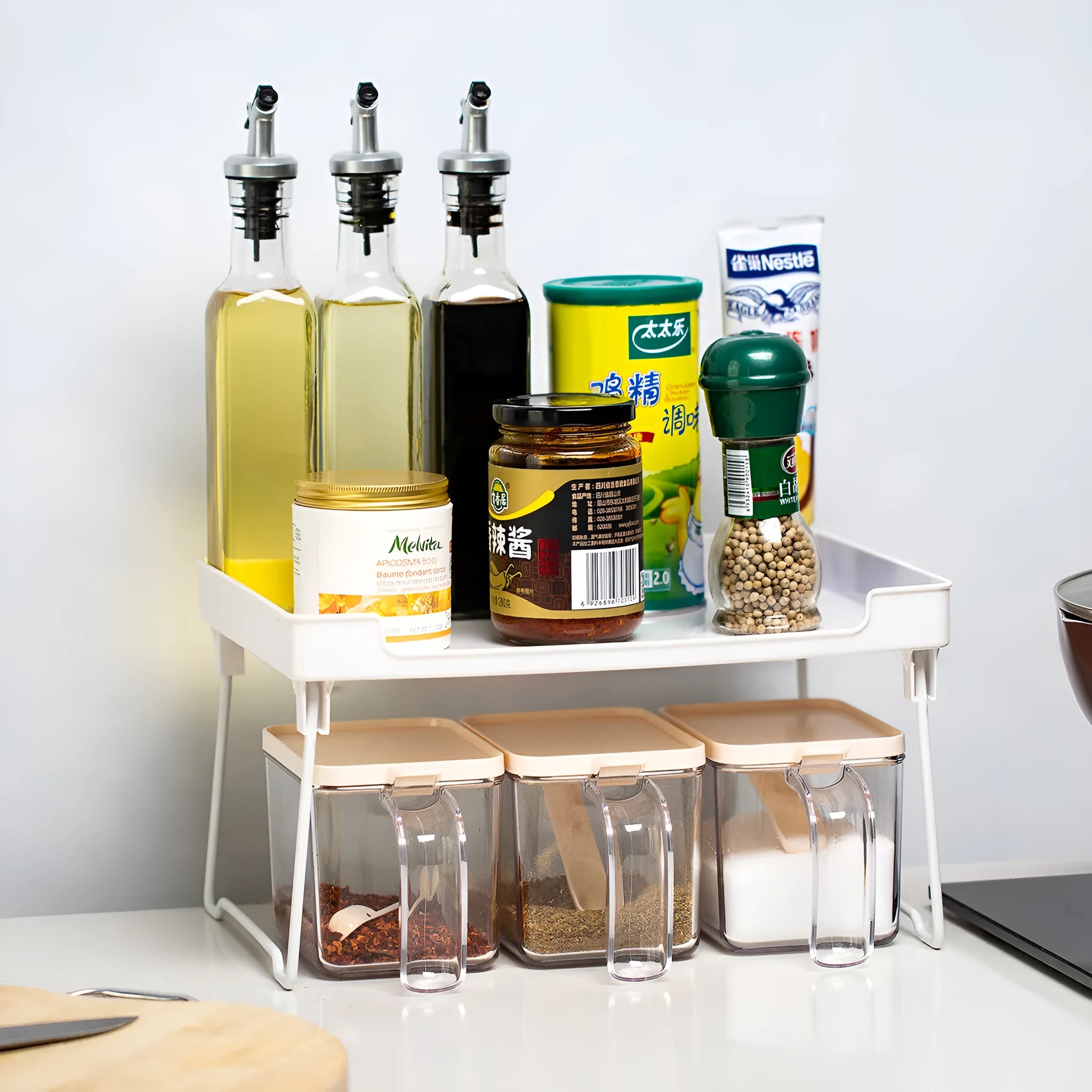 Plastic kitchen supplies rack in transparent colour on a countertop holding spice jars and small bottles