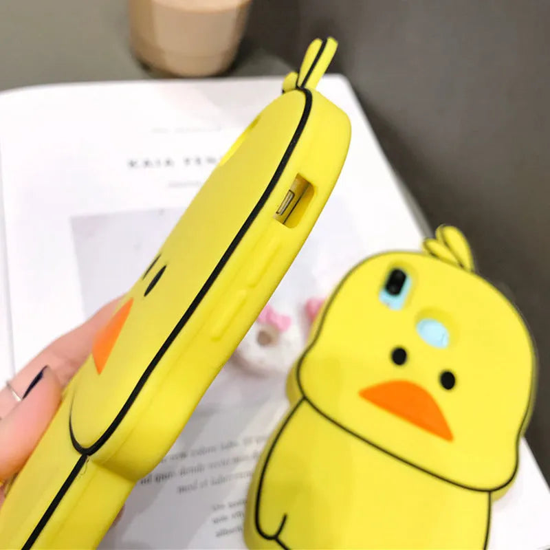 Green silicone iPhone case with a cartoon animal design on a table.