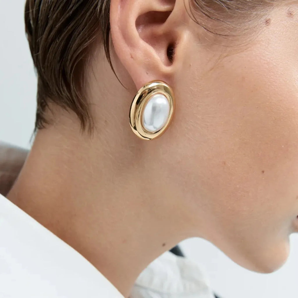 A pair of stainless steel vintage-style pearl stud earrings for women with an electroplated finish.