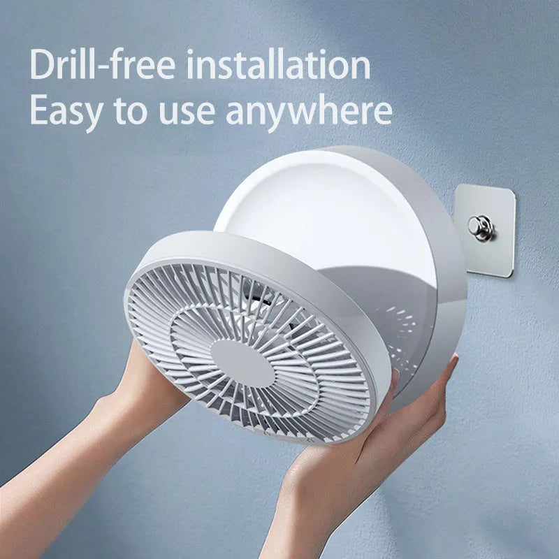 White portable folding fan with night light on a table, remote control beside it, showing its compact size.