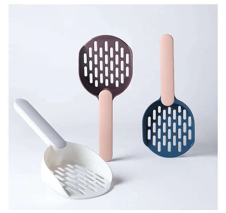 Plastic cat litter shovel in blue, green, and pink colours on a clean surface