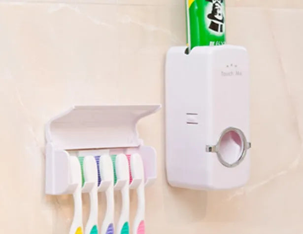White plastic and silicone bathroom accessories set with toothbrush holder and pump dispenser on a tiled wall