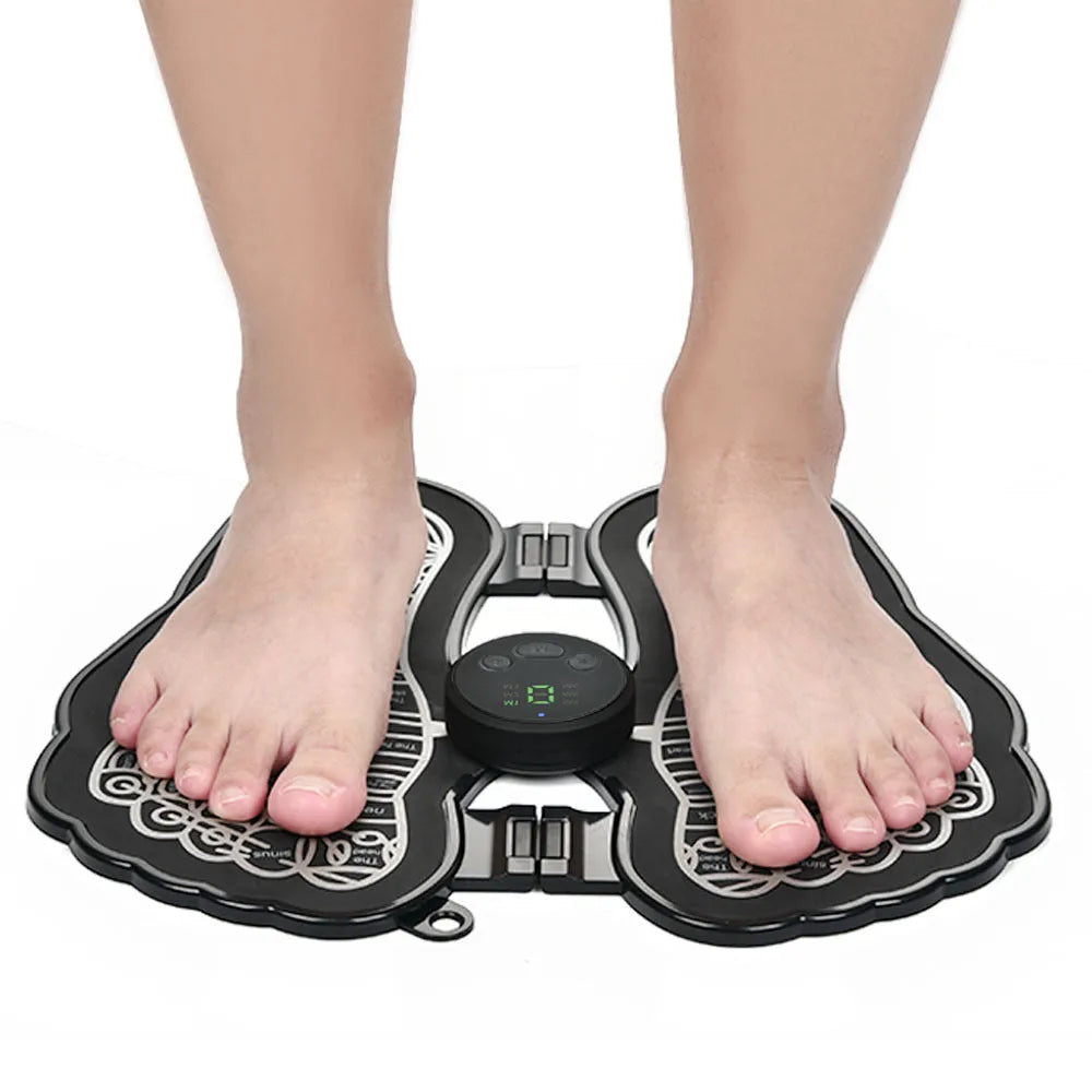 Black rechargeable foldable EMS foot massager pad with control host on floor